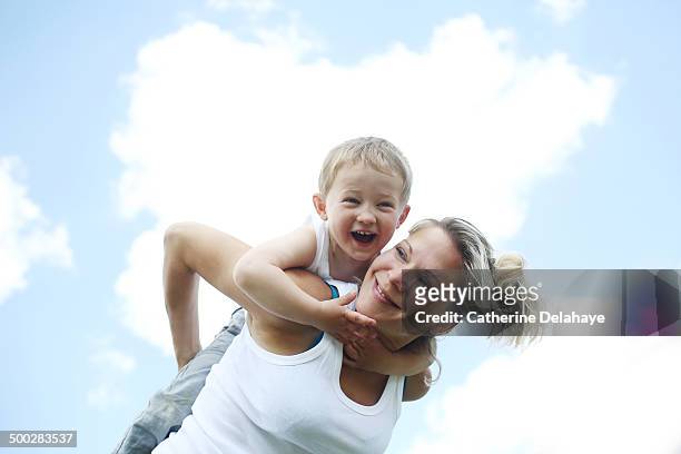 a 3 years old boy on the back of his mom - 30 34 years bildbanksfoton och bilder