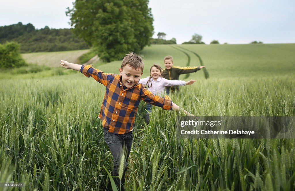 3 children running in a field