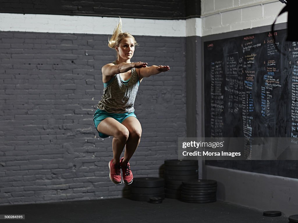 Female athlete practicing jumps in gym gym