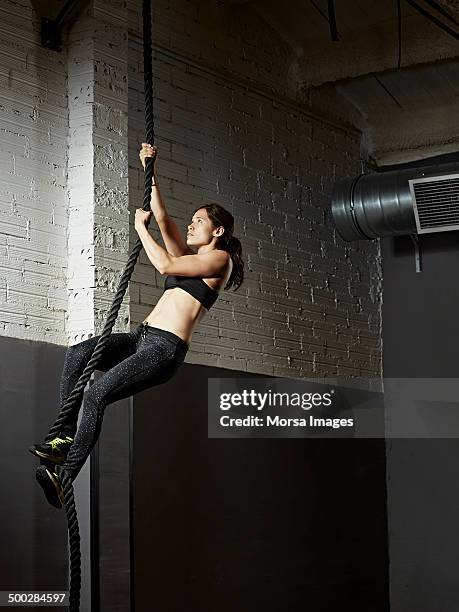 female gym climbing rope - woman climbing rope stock-fotos und bilder