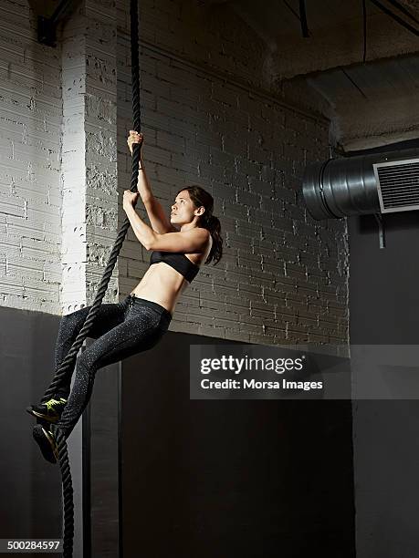 female gym climbing rope - entrenamiento combinado fotografías e imágenes de stock