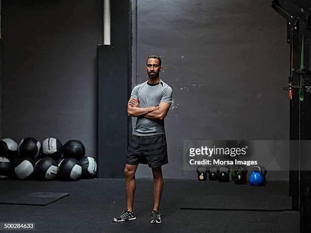 portrait of male athlete in gym gym - braços cruzados imagens e fotografias de stock