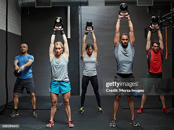 group of gymters practicing kettlebell - cross training foto e immagini stock