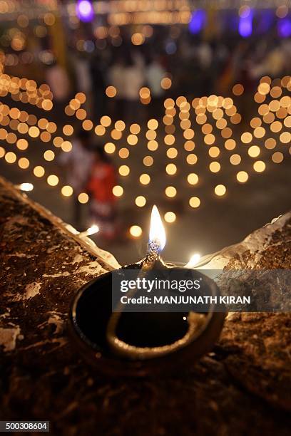 Hindu devotees light oil lamps at a temple for the Hindu God Shiva during the celebration of the Tamil Hindu festival of "Karthigai Deepam" in...