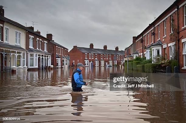 Local residents make their way through the flood water as they continue to leave their homes after severe flooding on December 7, 2015 in Carlisle,...