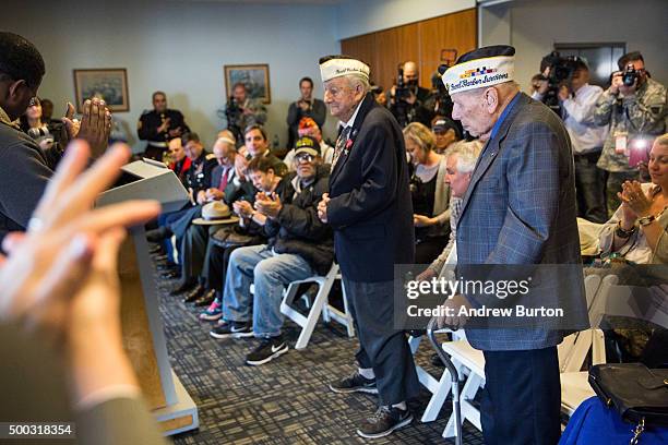 Aaron Chabin and Armando Galella, survivors of the attack on Pearl Harbor, stand to receive applause at a ceremony marking the anniversary of the...