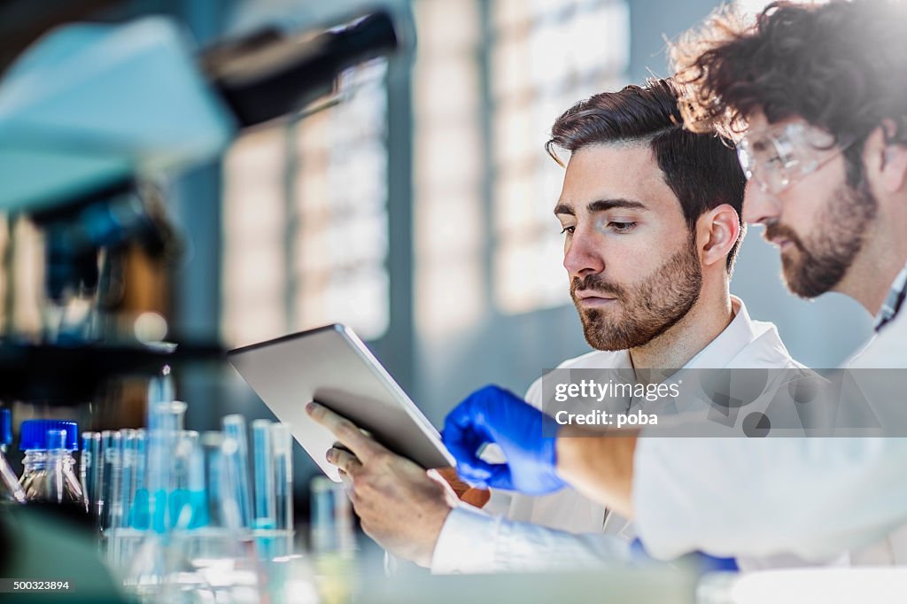 Two scientist using digital tablet in laboratory