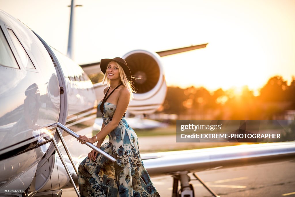 Young blonde woman entering private jet airplane