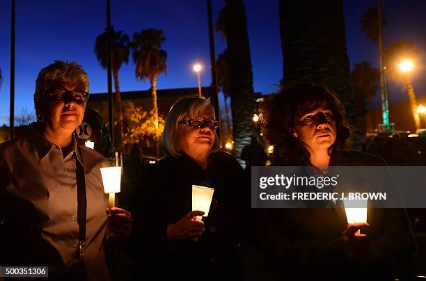 People gather at a candlelight vigil the San Bernardino County Board of Supervisors headquarters December 7, 2015 in San Bernardino, California, for...