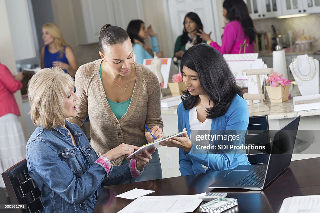 Group of women ordering jewelry at home sales party