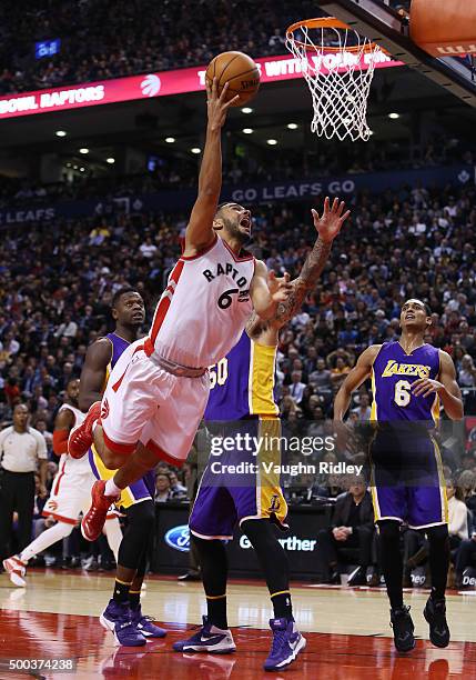 Cory Joseph of the Toronto Raptors is fouled by Robert Sacre of the Los Angeles Lakers as he drives to the basket during an NBA game at the Air...