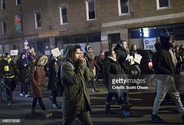 Demonstrators protesting the shooting death of Ronald Johnson march through the Washington Park neighborhood on December 7, 2015 in Chicago,...