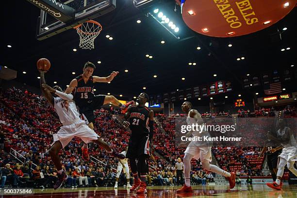 Winston Shepard of the San Diego State Aztecs shoots the ball and is fouled in the first half by Jeff Gonzalez of the Biola Eagles at Viejas Arena on...