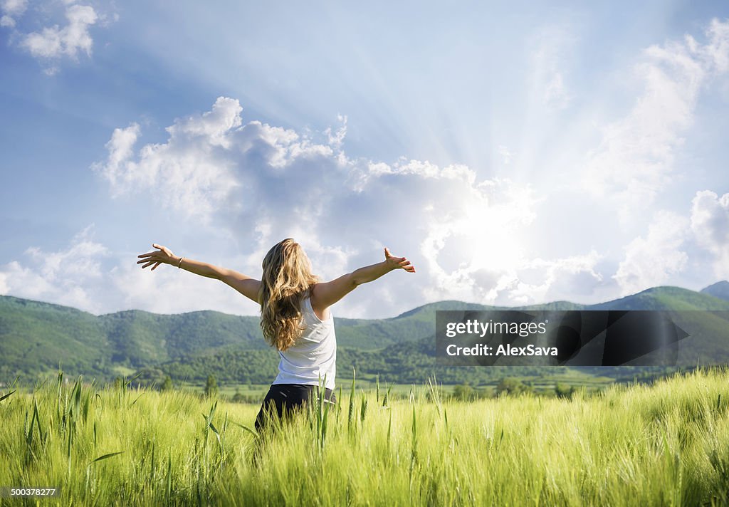 One young woman Feeling free outdoor in the wheat field