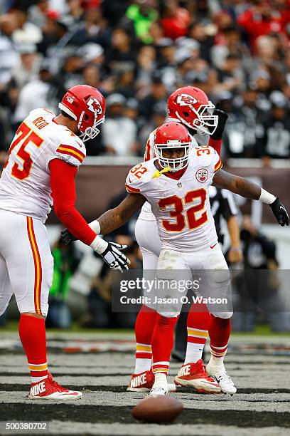 Running back Spencer Ware of the Kansas City Chiefs celebrates with offensive tackle Jah Reid after scoring a touchdown against the Oakland Raiders...