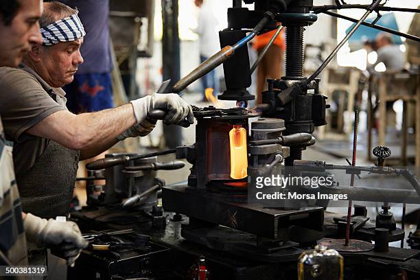 glass worker at blow molding machine - glass factory stock-fotos und bilder