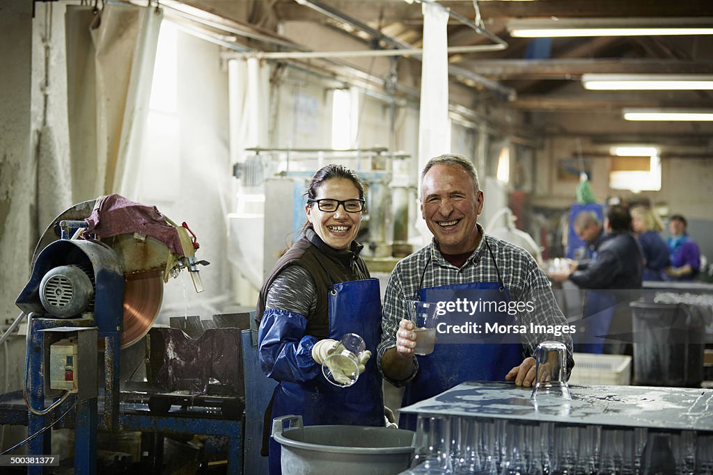 Smiling glass workers in factory