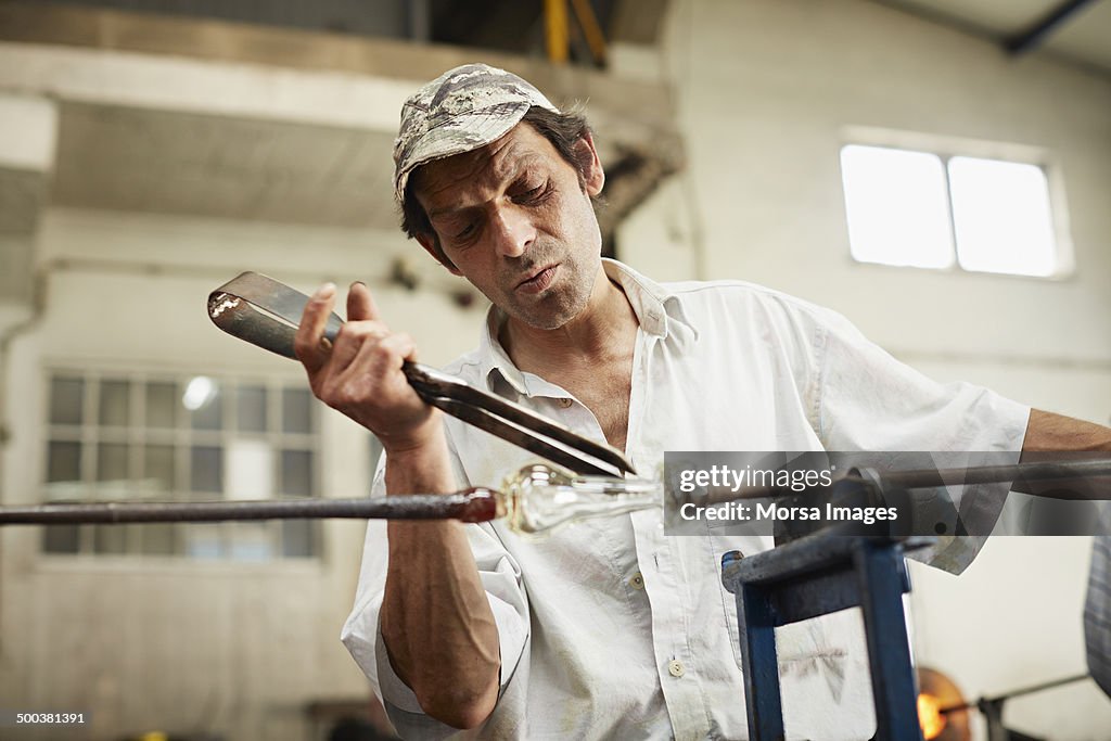 Glass worker separating piece from pipe