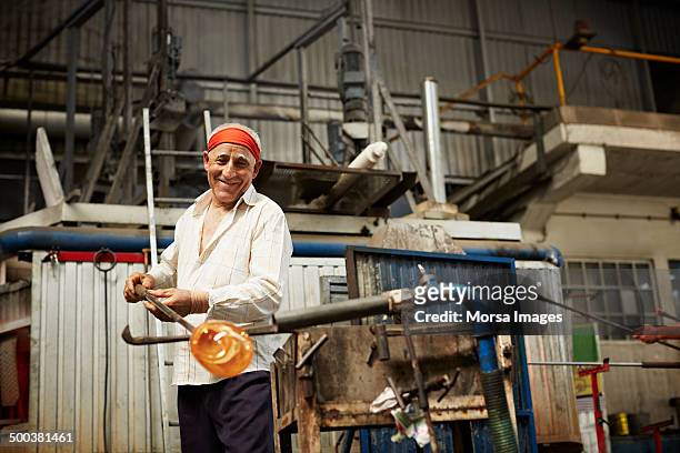 glass blower heating up glass - glass blowing stock pictures, royalty-free photos & images