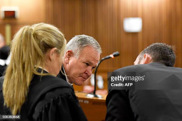 Former Paralympic champion Oscar Pistorius speaks to his lawyer Barry Roux before his hearing at the South African Gauteng Division High Court in...