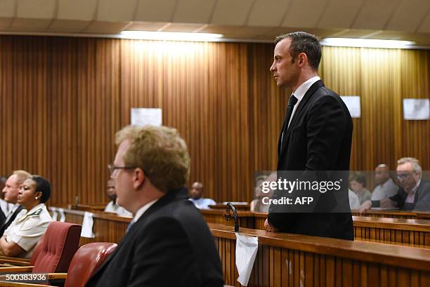 Former Paralympic champion Oscar Pistorius stands in the dock during his hearing at the South African Gauteng Division High Court in Pretoria, South...