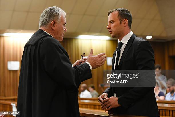 Former Paralympic champion Oscar Pistorius speaks to his lawyer Barry Roux during his hearing at the South African Gauteng Division High Court in...