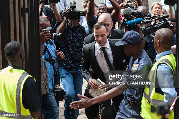 Former Paralympic champion Oscar Pistorius trips as he arrives for his hearing at the South African Gauteng Division High Court in Pretoria, South...