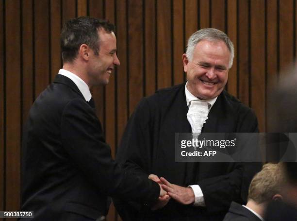 Former Paralympic champion Oscar Pistorius speaks with his lawyer Barry Roux at the North Gauteng High Court in Pretoria, South Africa during his...