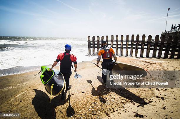 kayak surfers heading in the water - carrying kayak stock pictures, royalty-free photos & images