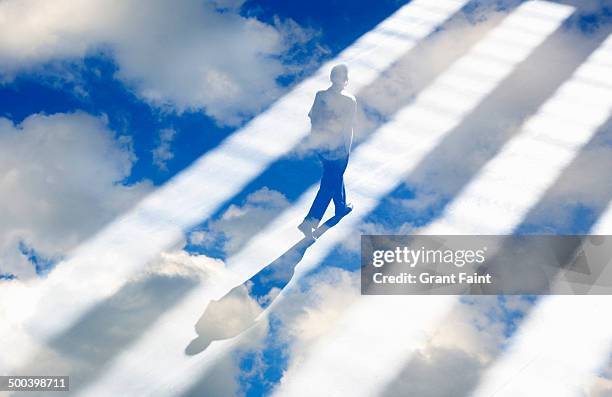 man walking in light rays - sunbeam clouds stock pictures, royalty-free photos & images