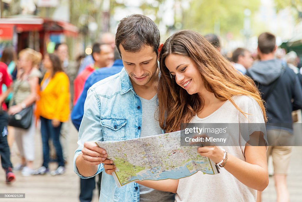 Barcelona Los turistas con Mapa de la ciudad en la Rambla