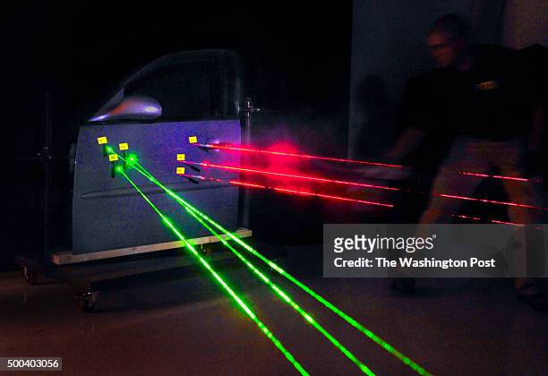 An technical staffer at the FBI Operational Technology Division lab shows how investigators use lasers to track the trajectory of bullets that were...