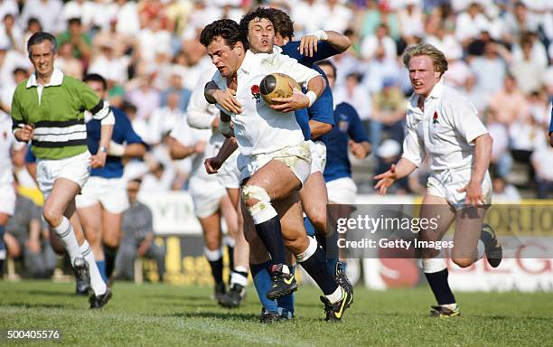 Will Carling of England makes a break watched by Neil Back during a match between Italy and England on May 1, 1990 in Rovigo, Italy.