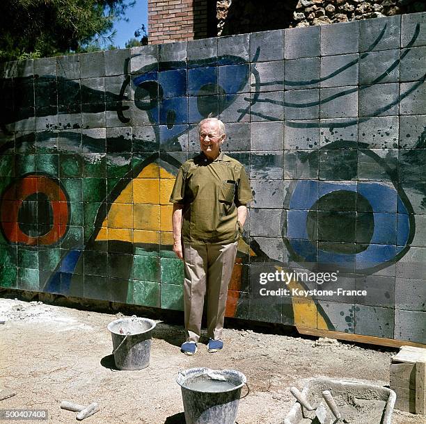 The painter, engraver, sculptor and ceramic artist Joan Miro in front of one of his works, a ceramic mural fresco in his garden on July 18, 1968 in...