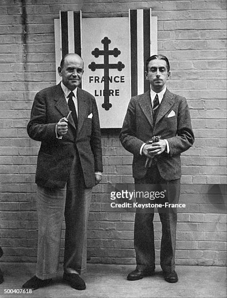 Les resistants Pierre Brossolette et Charles Vallin , debout devant un drapeau des Forces de la France libre, a Londres, pendant la Seconde Guerre...