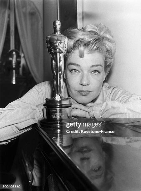 Back from Hollywood, Simone Signoret poses in her Paris apartment with the Best Actress Oscar she won for her role in the film 'Room at the Top',...