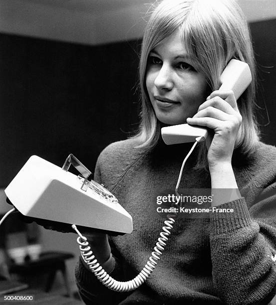 Jeune femme essayant un nouveau telephone design mis sur le marche par le General Post Office, GPO le 4 mai, 1965 a Londres, Royaume-Uni.
