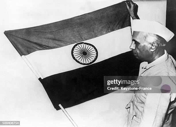 The vice President of India, Jawaharlal Nehru, presenting the national flag of India during a meeting of the constituent assembly, the flag is made...