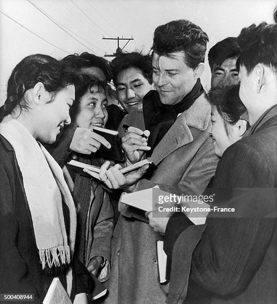 The French actor Gerard Philipe signing autographs to some Chinese students on March 4, 1957 in Beijing, China.