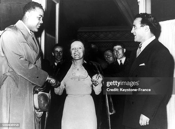 In a Parisian cabaret, Edith Piaf poses between two boxers, the American Joe Louis and her partner the French Marcel Cerdan on June 02, 1948 in...