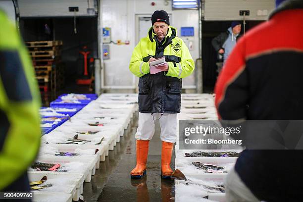 Fish market trader makes notes during the cod sale at Peterhead Fish Market and Port, operated by Peterhead Port Authority, in Peterhead, U.K., on...