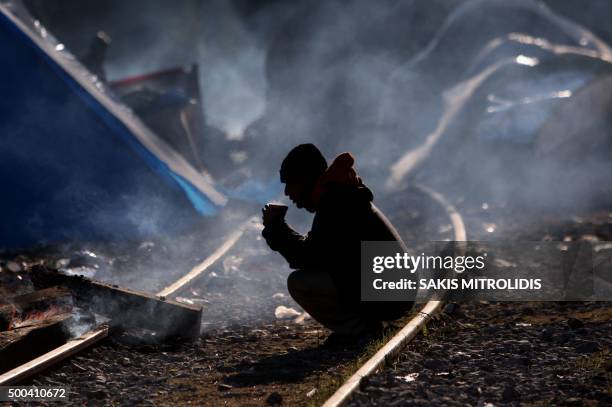 Man sits on rail tracks as migrants and refugees wait to cross the Greek-Macedonian border near Idomeni on December 8, 2015. Since last week,...