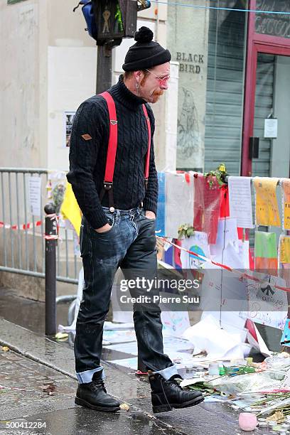 Eagles of Death Metal frontman Jesse Hughes shows his emotions as he looks at the flower memorial in front of The Bataclan concert hall on December...