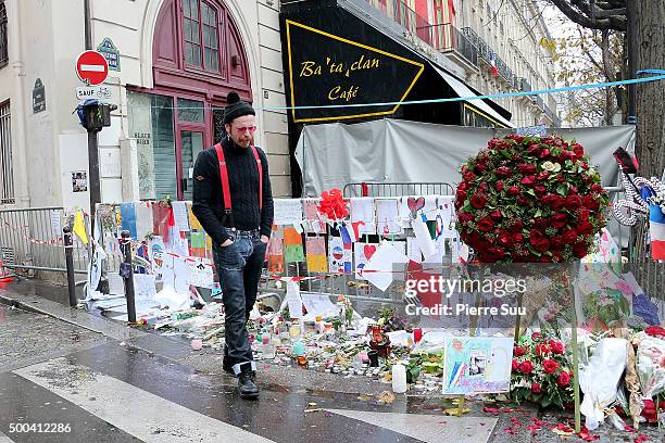 Eagles of Death Metal frontman Jesse Hughes shows his emotions as he looks at the flower memorial in front of The Bataclan concert hall on December...