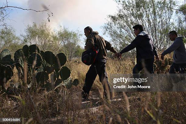 Immigrants walk handcuffed after illegally crossing the U.S.-Mexico border and being caught by the U.S. Border Patrol on December 7, 2015 near Rio...