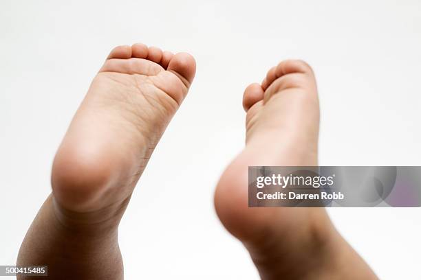 baby girl's feet raised in the air - baby feet stock pictures, royalty-free photos & images