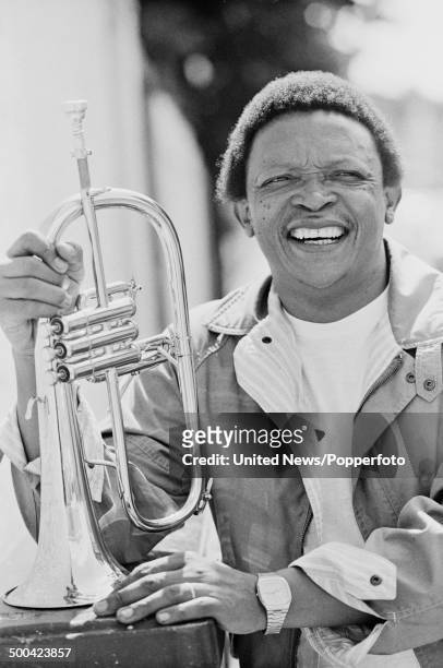 South African trumpet player Hugh Masekela posed holding a trumpet outside Zomba recording studios in Harlesden, London on 9th August 1984.