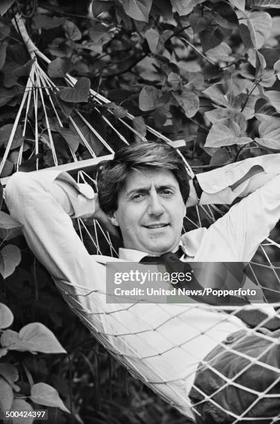 Scottish actor Tom Conti posed lying in a hammock in a garden in London on 27th June 1984.