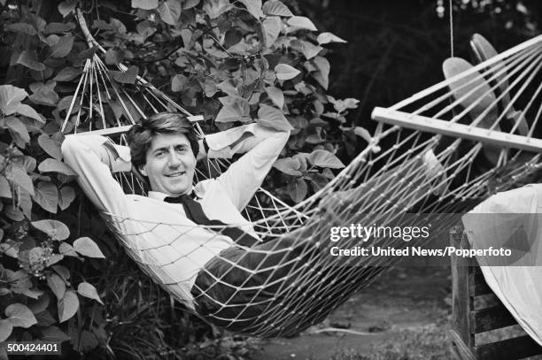 Scottish actor Tom Conti posed lying in a hammock in a garden in London on 27th June 1984.