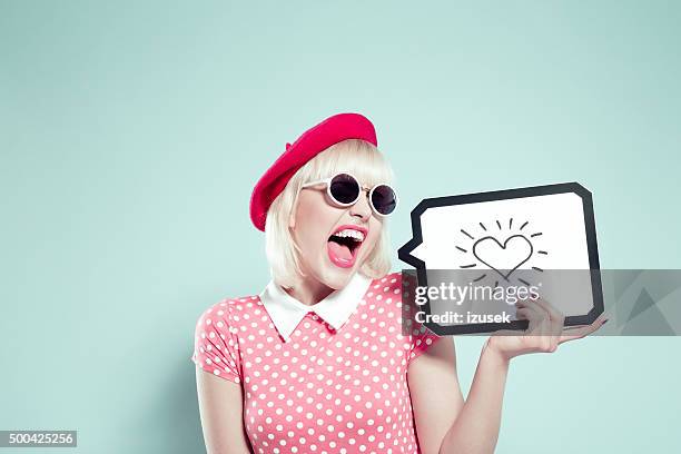 excited blonde young woman holding speech bubble with drawn heart - happy face drawing stock pictures, royalty-free photos & images